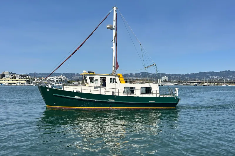Carquinas Coot Yacht Photos Pics Green Seahorse COOT 2010 boat on calm water with cityscape background.