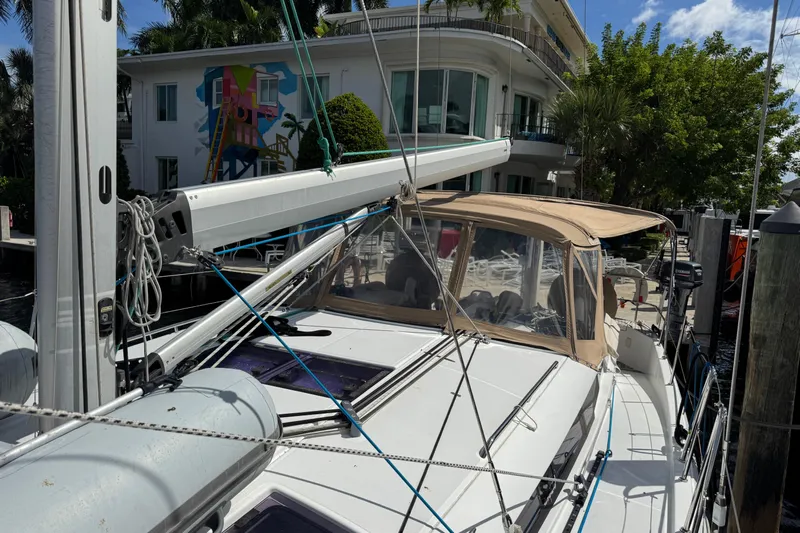 Reventador Yacht Photos Pics 2018 Jeanneau Sun Odyssey 440 sailboat docked near modern waterfront home.