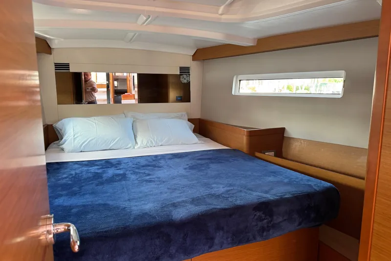 Reventador Yacht Photos Pics Cozy cabin interior of 2018 Jeanneau Sun Odyssey 440 sailboat with blue bedding.