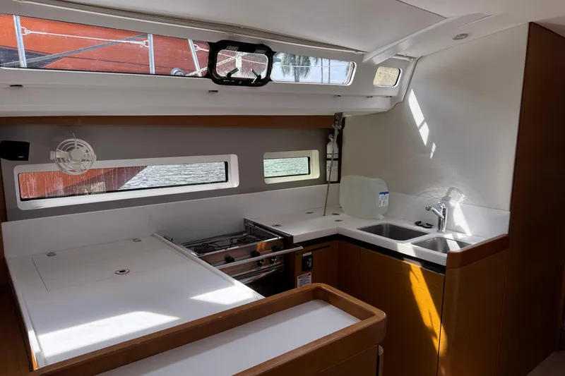 Reventador Yacht Photos Pics Modern kitchen interior of 2018 Jeanneau Sun Odyssey 440 yacht, featuring sleek design and ample lighting.