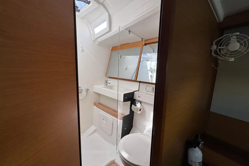 Reventador Yacht Photos Pics Bathroom interior of 2018 Jeanneau Sun Odyssey 440 yacht, featuring modern fixtures and wooden accents.