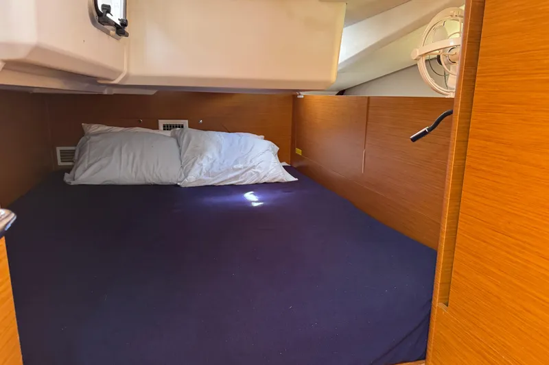 Reventador Yacht Photos Pics Cozy cabin interior of 2018 Jeanneau Sun Odyssey 440 sailboat with pillows and blue bedding.