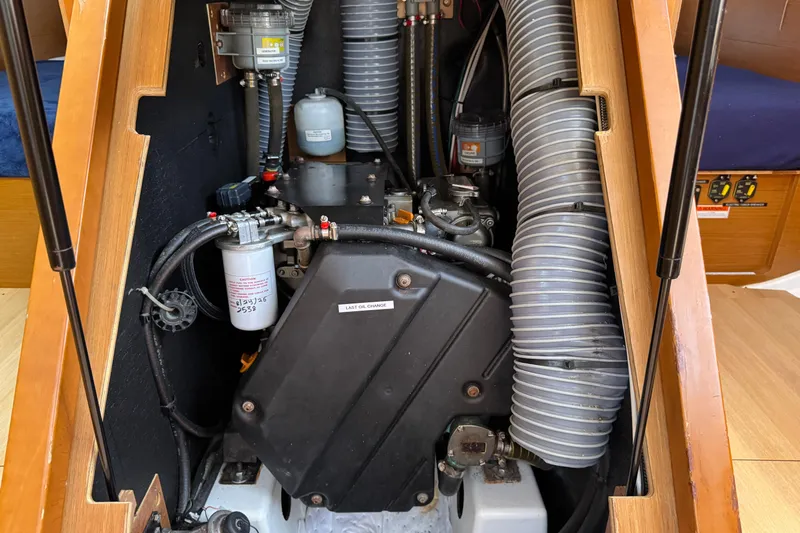 Reventador Yacht Photos Pics Engine compartment of 2018 Jeanneau Sun Odyssey 440 sailboat, showcasing mechanical components and hoses.