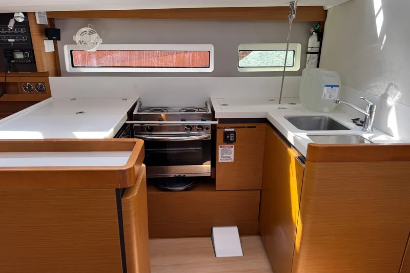 Reventador Yacht Photos Pics Modern kitchen interior of 2018 Jeanneau Sun Odyssey 440 yacht, featuring stove and sink.
