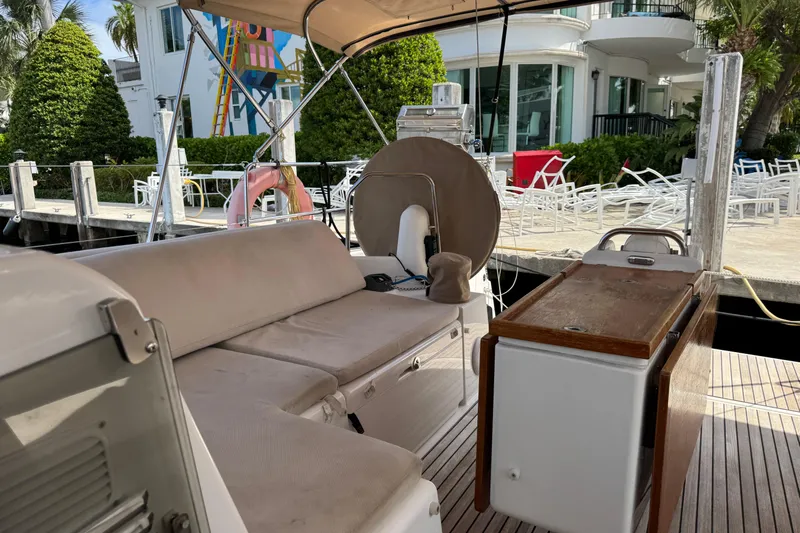 Reventador Yacht Photos Pics 2018 Jeanneau Sun Odyssey 440 yacht interior with seating and table, docked near modern building.