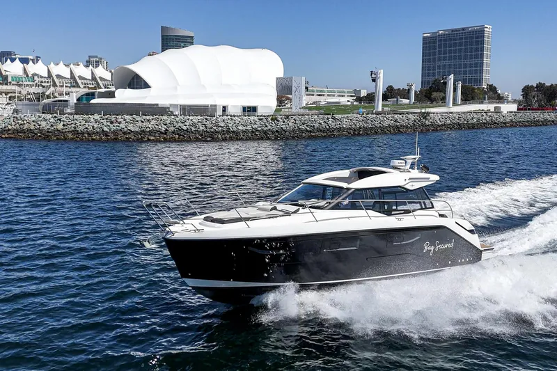 Bag Secured Yacht Photos Pics 2023 Bavaria SR36 yacht cruising near modern waterfront buildings.