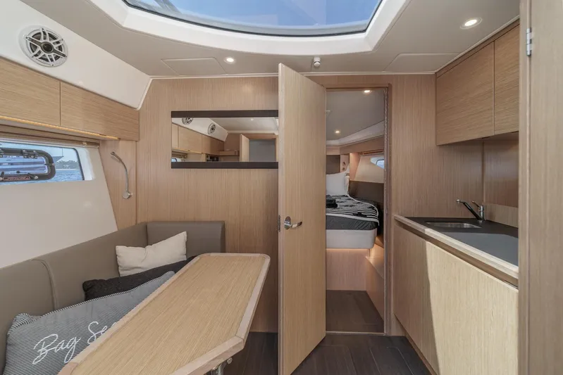 Bag Secured Yacht Photos Pics Interior of 2023 Bavaria SR36 yacht, featuring modern wood finishes and cozy seating area.