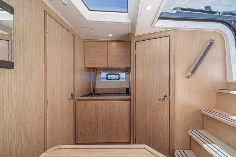 Bag Secured Yacht Photos Pics Interior of 2023 Bavaria SR36 yacht, featuring modern wood finish and compact kitchen area.