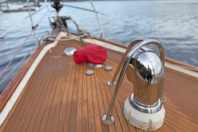 Raison D'etre Yacht Photos Pics Deck of 1988 Hallberg Rassy 42E sailboat with polished metal fittings and wooden finish.