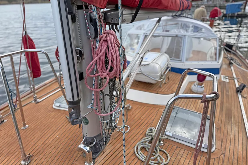 Raison D'etre Yacht Photos Pics 1988 Hallberg Rassy 42E sailboat deck with ropes and wooden finish, docked by the water.