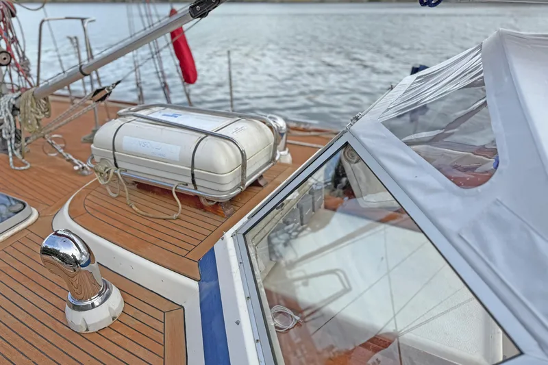 Raison D'etre Yacht Photos Pics 1988 Hallberg Rassy 42E sailboat deck with liferaft and polished fittings.