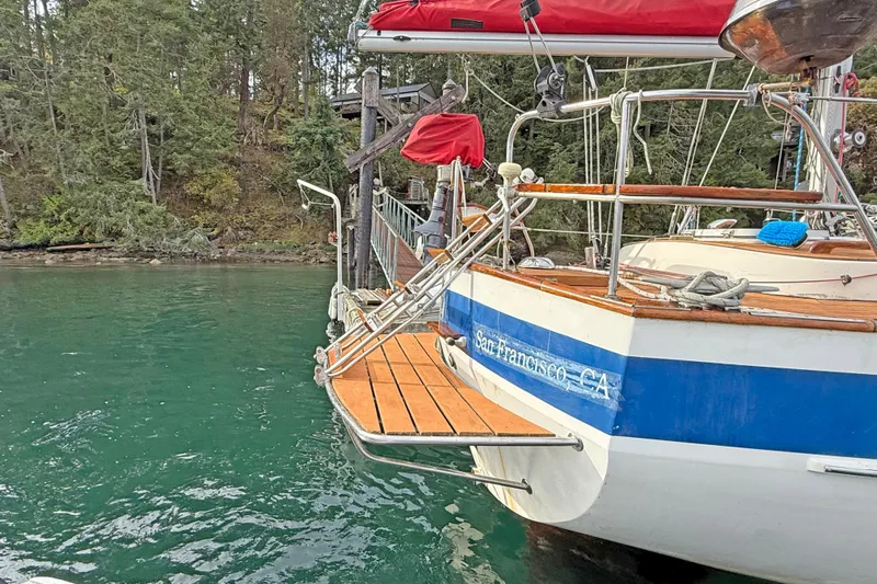 Raison D'etre Yacht Photos Pics 1988 Hallberg Rassy 42E sailboat docked in serene forested waters.