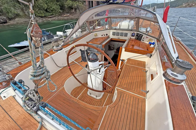 Raison D'etre Yacht Photos Pics 1988 Hallberg Rassy 42E sailboat cockpit with wooden deck and steering wheel.