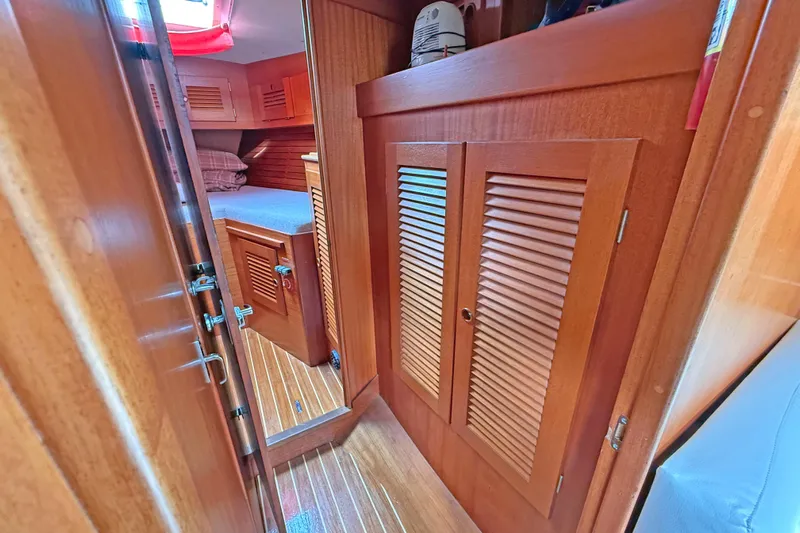 Raison D'etre Yacht Photos Pics Interior of 1988 Hallberg Rassy 42E sailboat, featuring wooden cabinetry and cozy sleeping quarters.