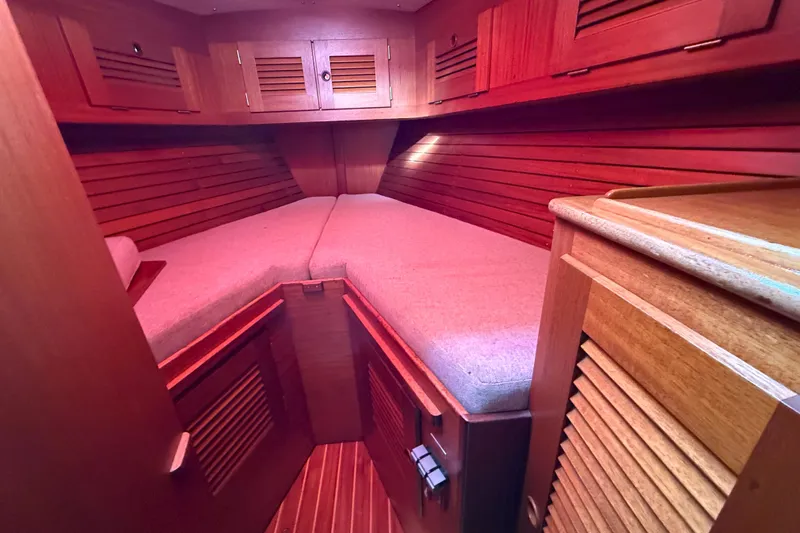 Raison D'etre Yacht Photos Pics 1988 Hallberg Rassy 42E yacht cabin with wooden interior and cozy bedding.