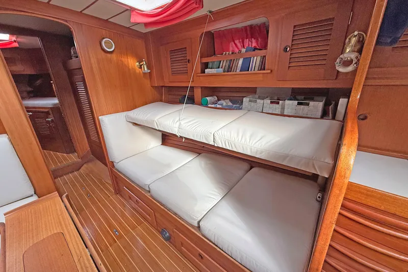 Raison D'etre Yacht Photos Pics Interior of 1988 Hallberg Rassy 42E sailboat with wooden finish and cushioned seating.