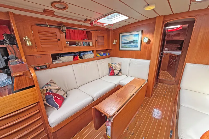 Raison D'etre Yacht Photos Pics Interior of 1988 Hallberg Rassy 42E yacht with cozy seating and wooden finishes.