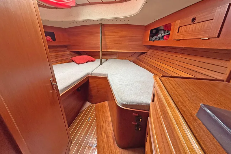 Raison D'etre Yacht Photos Pics Cozy cabin interior of 1988 Hallberg Rassy 42E sailboat with wooden finish and bedding.