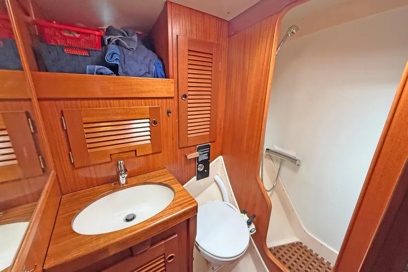 Raison D'etre Yacht Photos Pics Hallberg Rassy 42E 1988 yacht bathroom with wooden cabinetry and shower area.