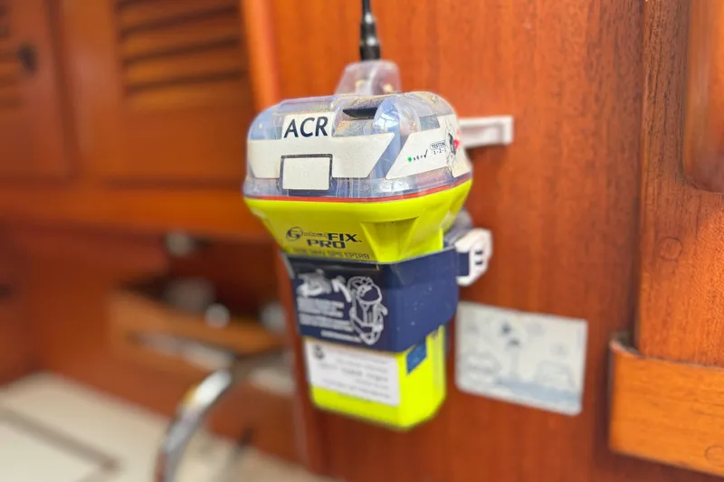 Raison D'etre Yacht Photos Pics Emergency beacon on 1988 Hallberg Rassy 42E yacht interior, mounted on wooden panel.