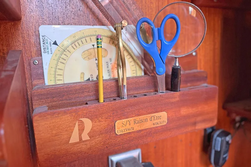Raison D'etre Yacht Photos Pics Navigation tools on Hallberg Rassy 42E yacht, 1988 model, with a wooden holder and engraved nameplate.
