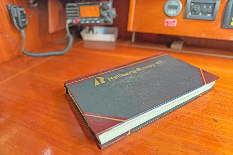Raison D'etre Yacht Photos Pics Logbook on Hallberg Rassy 42E yacht's wooden navigation desk, 1988 model.