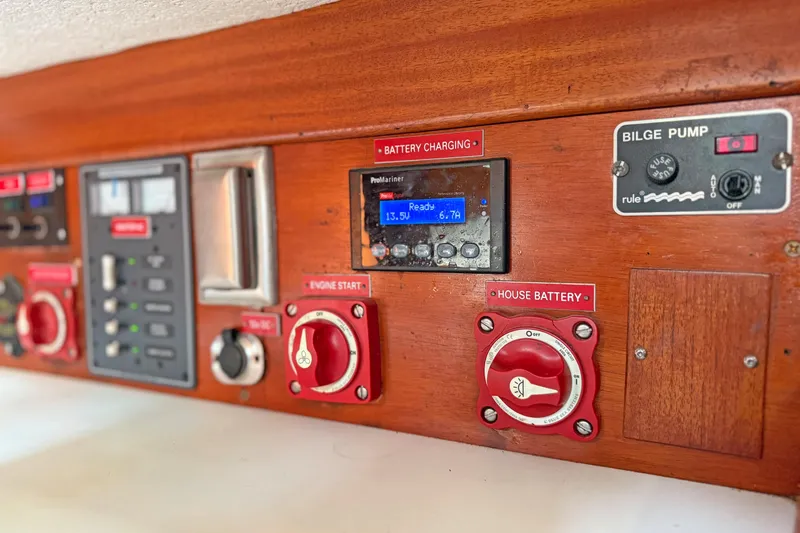 Raison D'etre Yacht Photos Pics Control panel of a 1988 Hallberg Rassy 42E yacht, featuring battery and bilge pump controls.