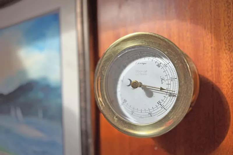 Raison D'etre Yacht Photos Pics Barometer on Hallberg Rassy 42E yacht, 1988 model, with wooden panel background.