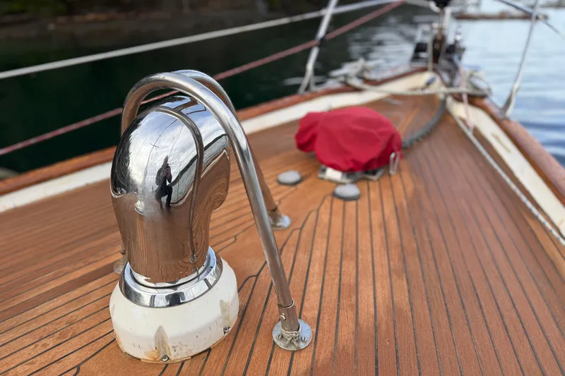 Raison D'etre Yacht Photos Pics Polished deck of 1988 Hallberg Rassy 42E sailboat with chrome fittings and red cover.
