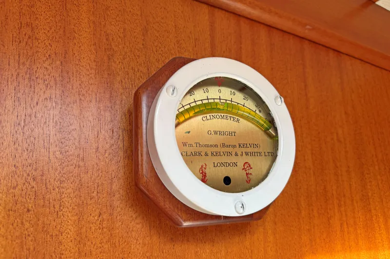 Raison D'etre Yacht Photos Pics Clinometer on 1988 Hallberg Rassy 42E yacht, wooden panel background.