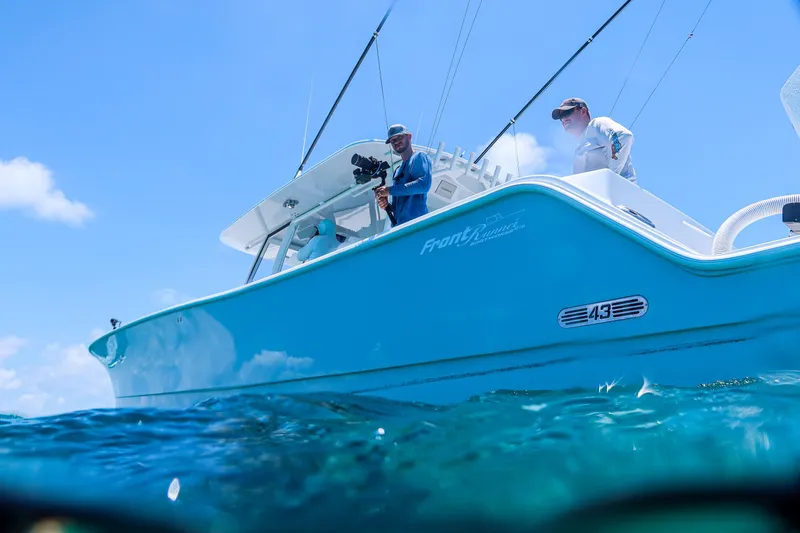  Yacht Photos Pics 2026 Front Runner 43 Catamaran on clear blue water, featuring fishing rods and crew.