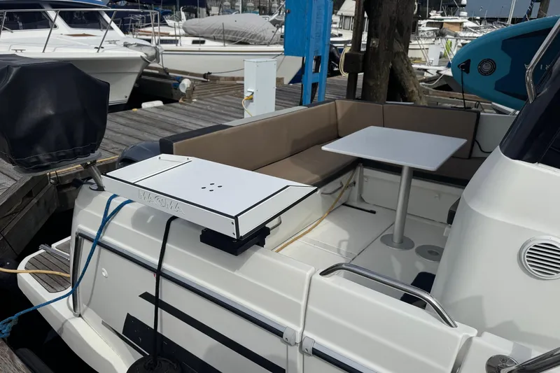  Yacht Photos Pics Jeanneau 895 Offshore 2017 boat with seating area and table at marina.