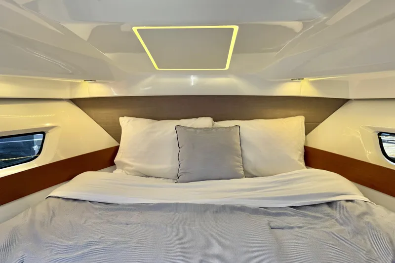  Yacht Photos Pics Cozy cabin interior of 2017 Jeanneau 895 Offshore with comfortable bedding.
