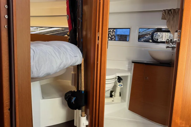  Yacht Photos Pics Interior of 2017 Jeanneau 895 Offshore boat, featuring cozy cabin and compact bathroom.