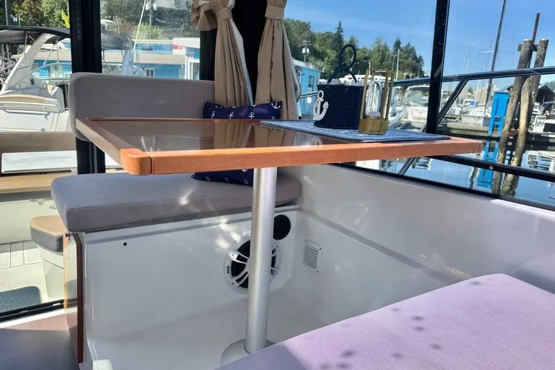  Yacht Photos Pics Interior of 2017 Jeanneau 895 Offshore boat with table and seating area.