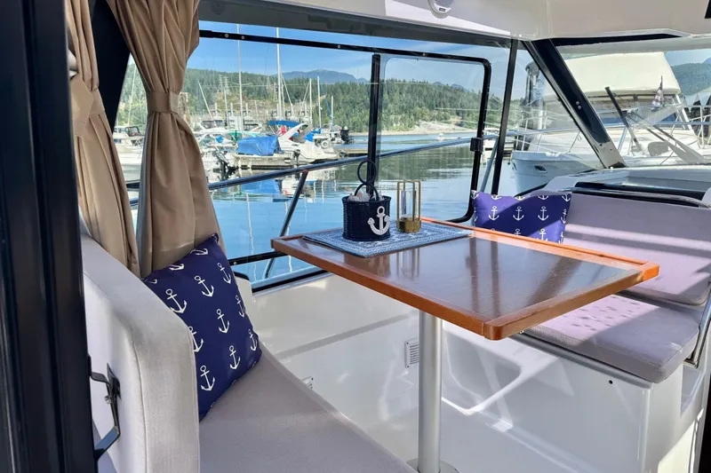  Yacht Photos Pics Interior of 2017 Jeanneau 895 Offshore boat with nautical-themed decor and marina view.