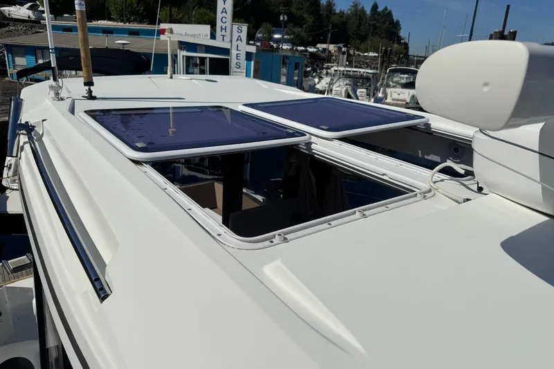  Yacht Photos Pics 2017 Jeanneau 895 Offshore boat with open sunroof, docked at marina.
