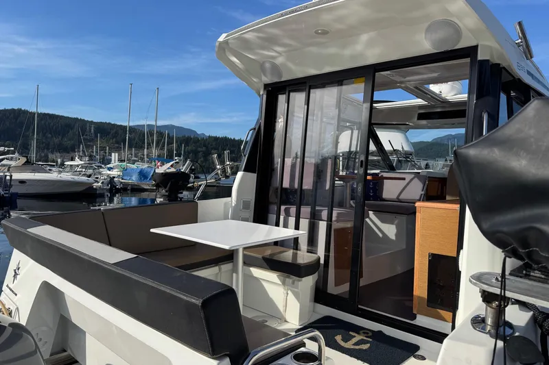  Yacht Photos Pics 2017 Jeanneau 895 Offshore boat docked, featuring spacious seating and sliding glass doors.