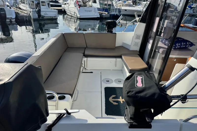  Yacht Photos Pics 2017 Jeanneau 895 Offshore boat interior with cushioned seating at a marina.