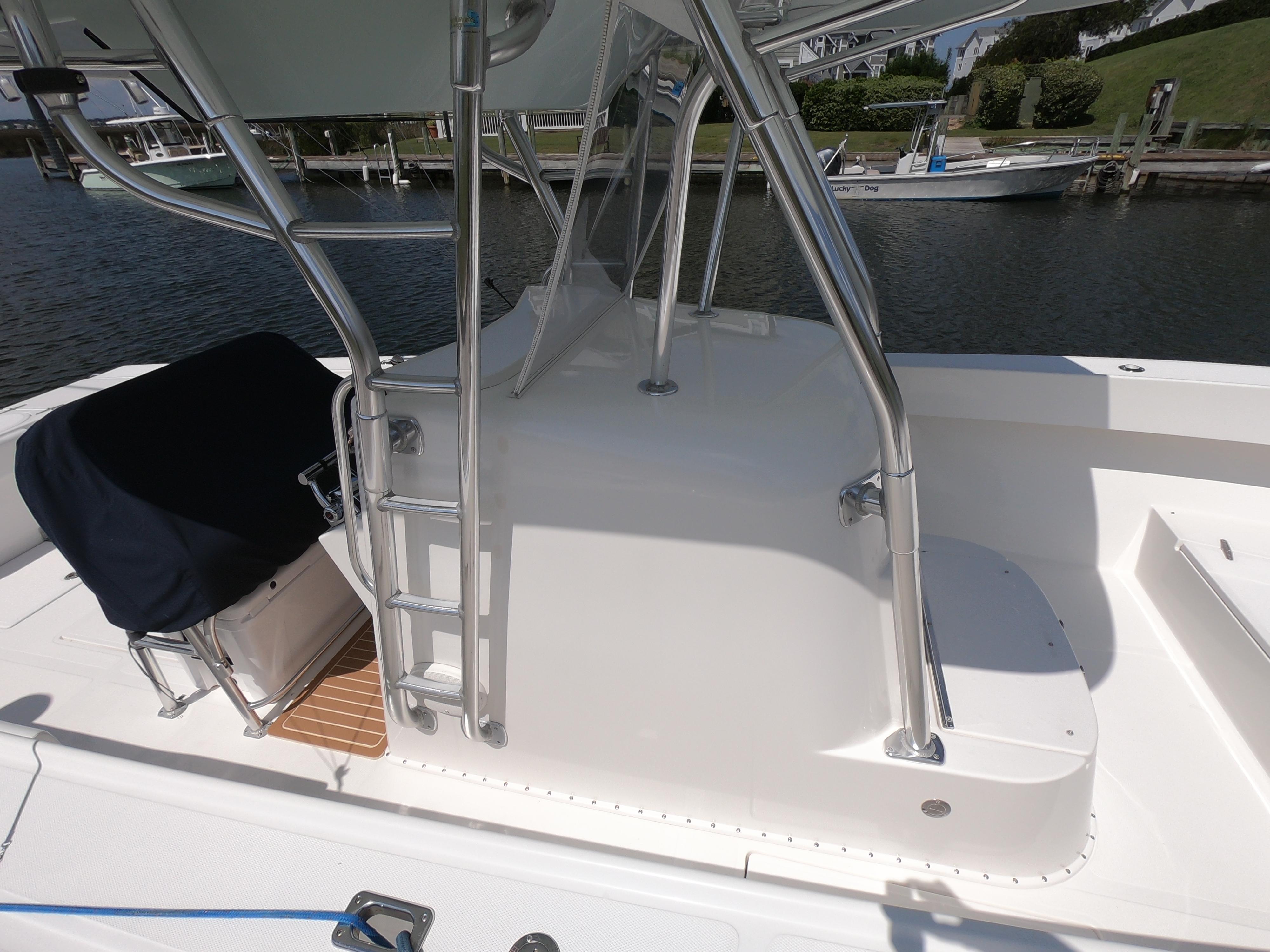 2003 Venture 34 Open boat with ladder and seating, docked by the water.