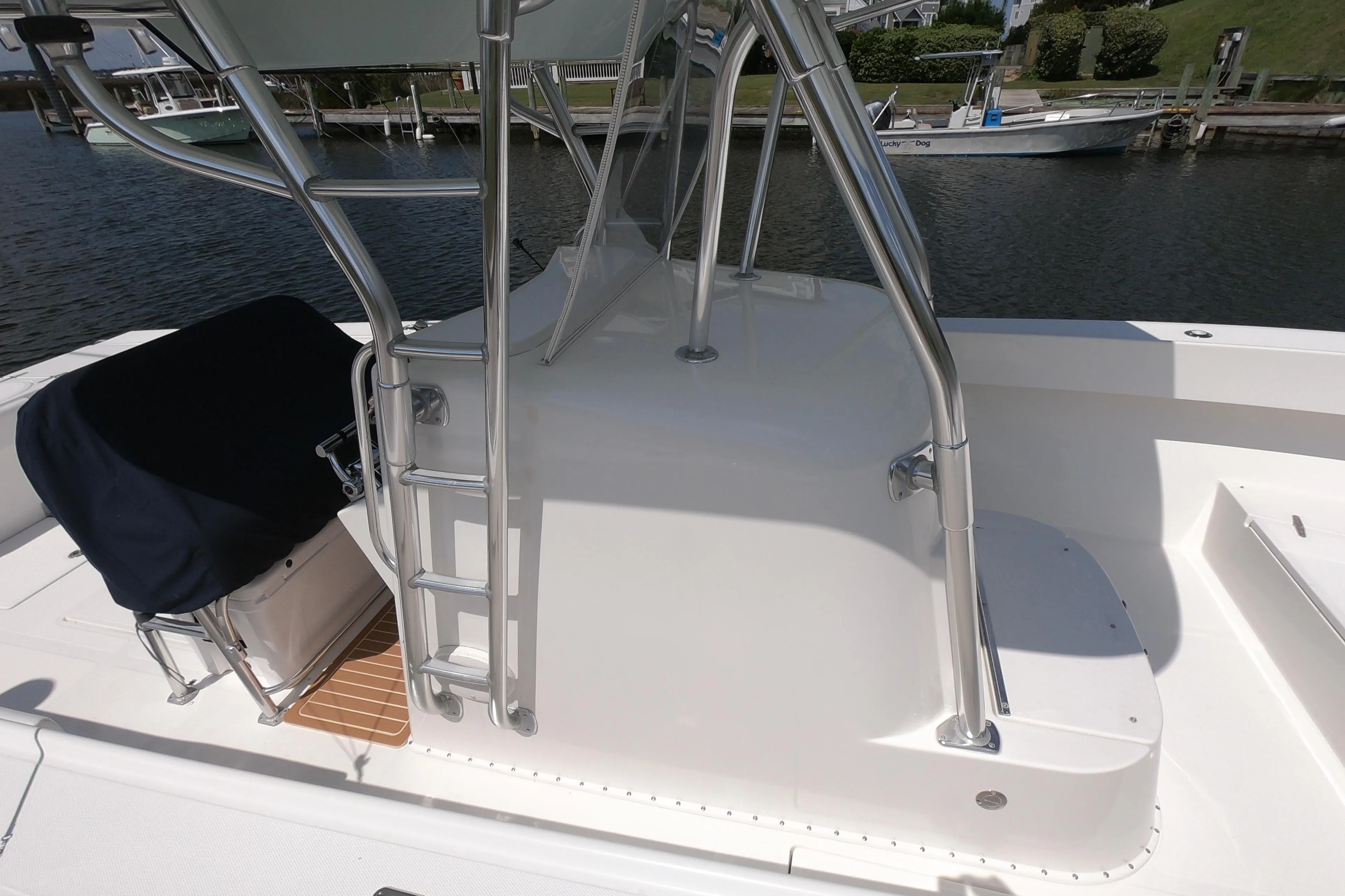 2003 Venture 34 Open boat with ladder and seating, docked by the water.
