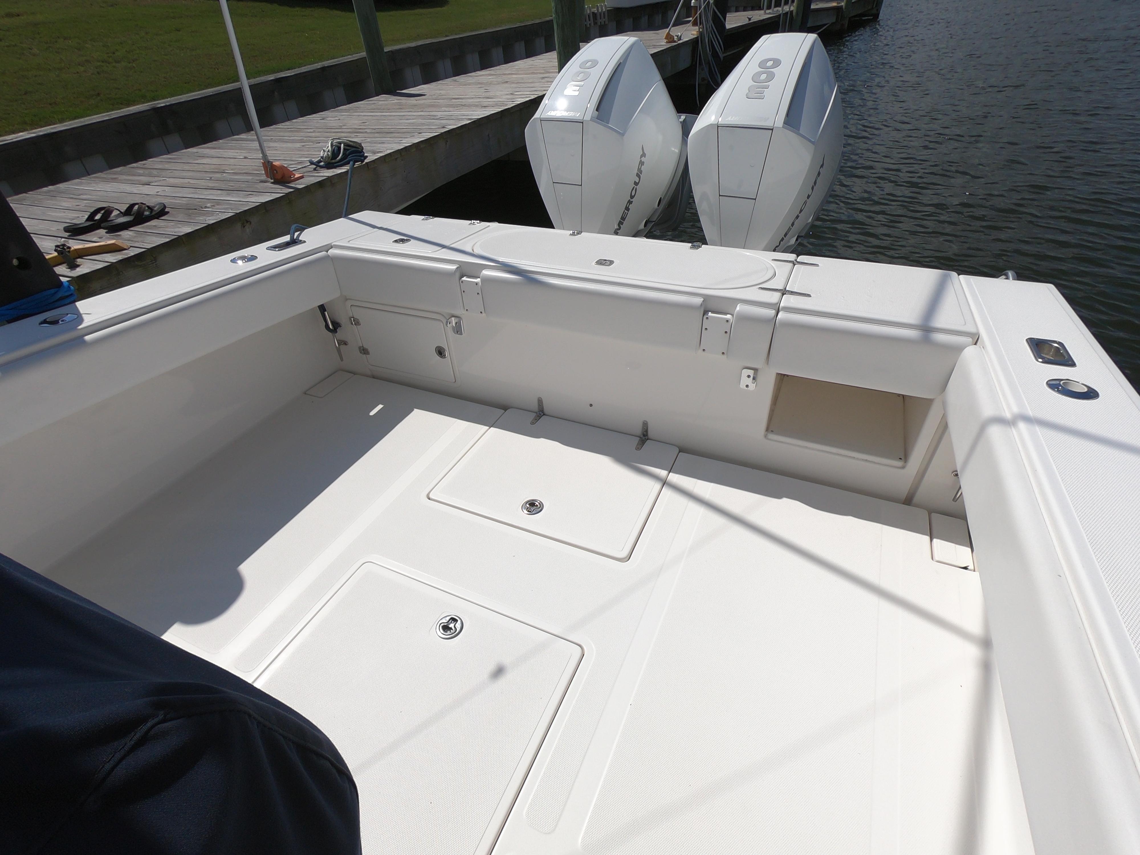 2003 Venture 34 Open boat deck with twin outboard engines at dock.