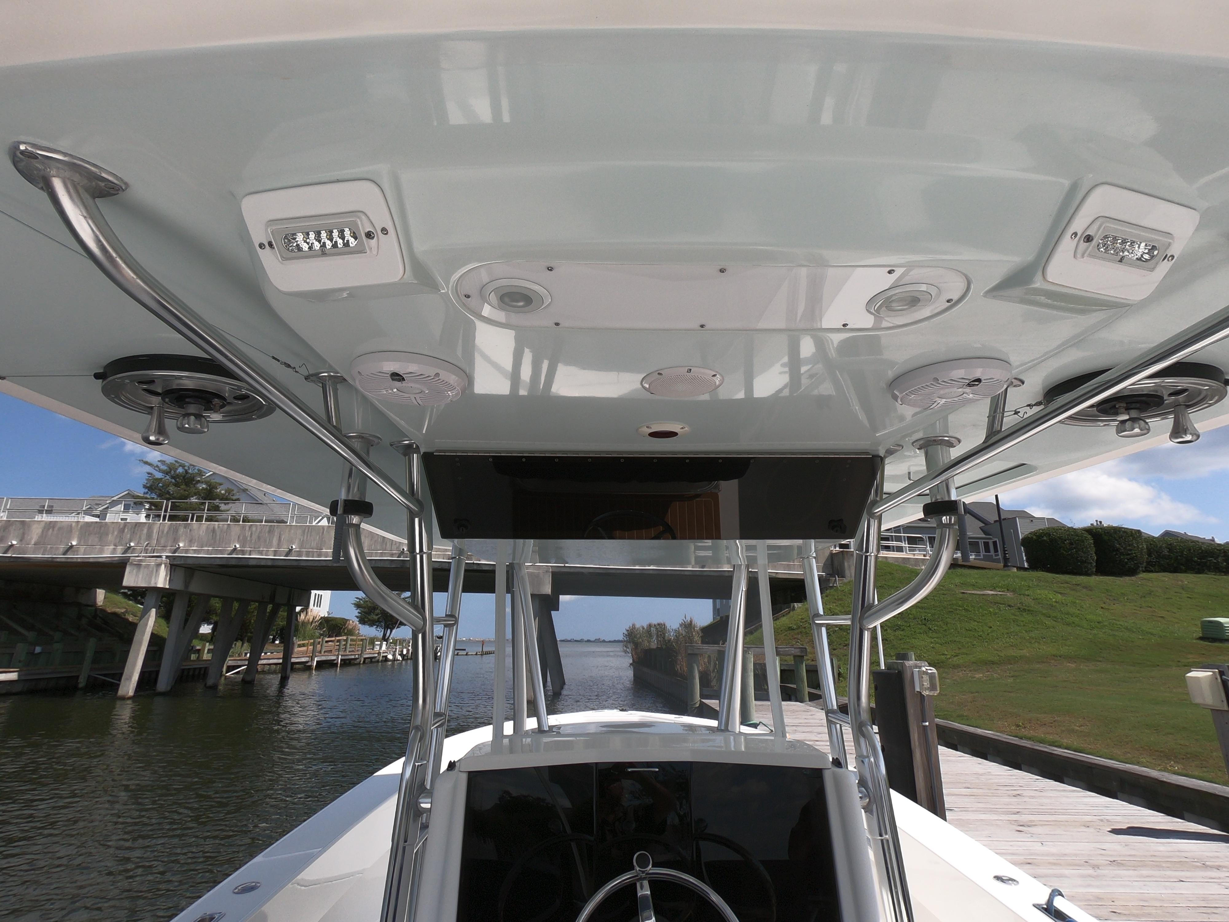 2003 Venture 34 Open boat, view of helm and T-top structure by a dock.