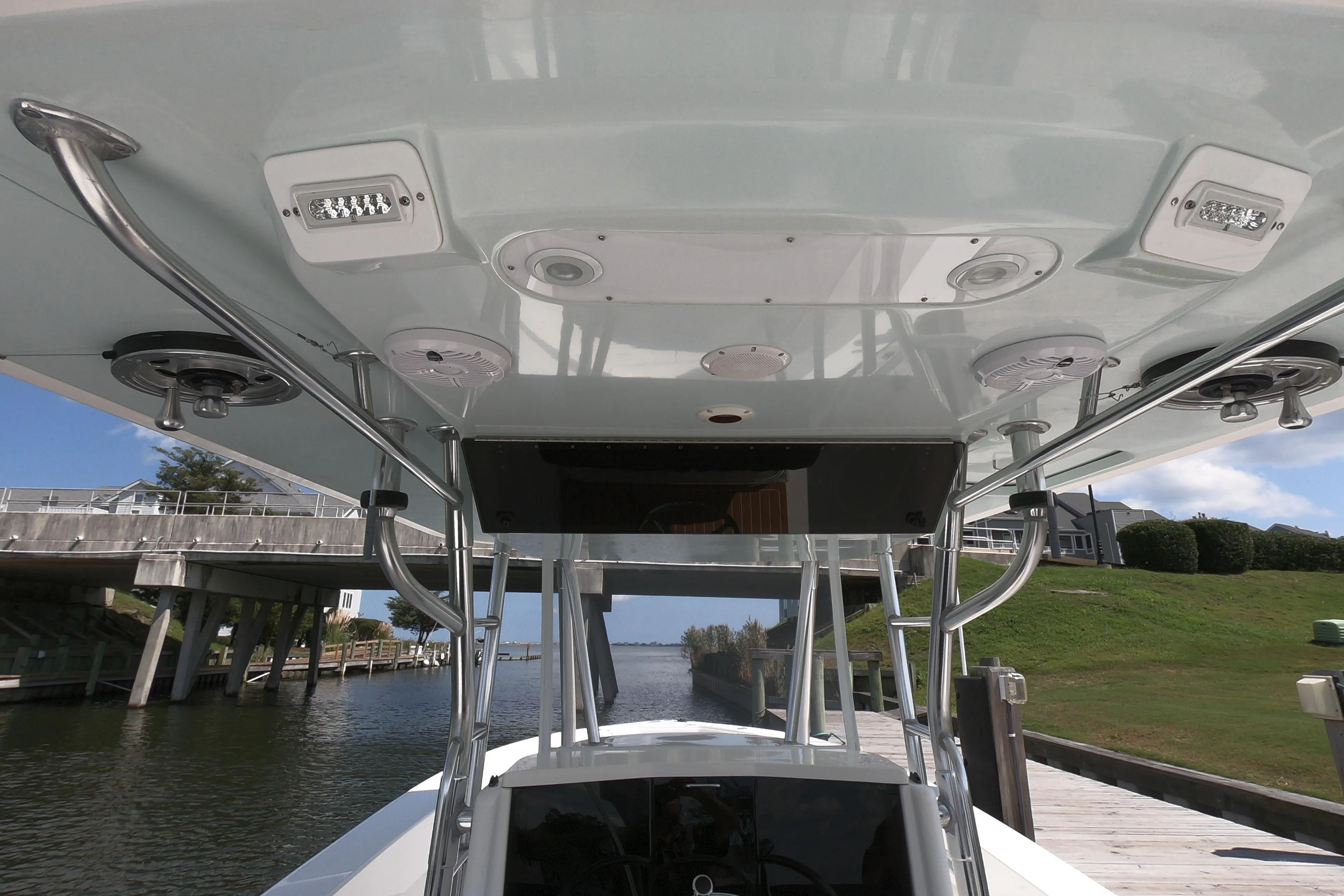 2003 Venture 34 Open boat, view of helm and T-top structure by a dock.