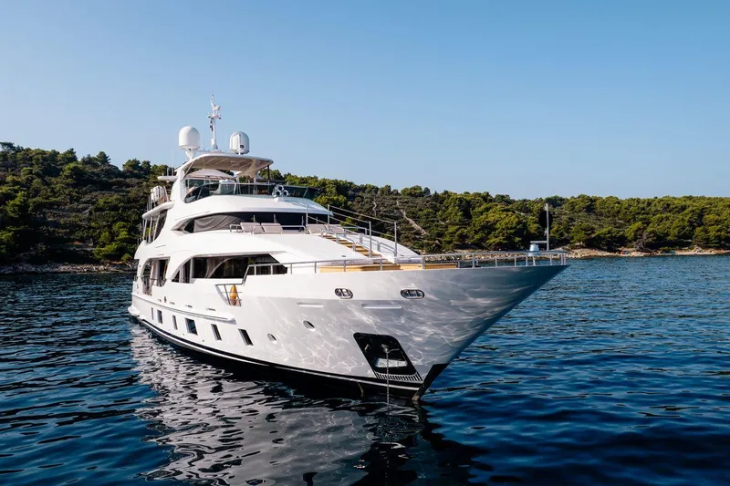Afina Yacht Photos Pics Luxurious 2017 Benetti 108 yacht cruising in serene waters, surrounded by lush greenery.