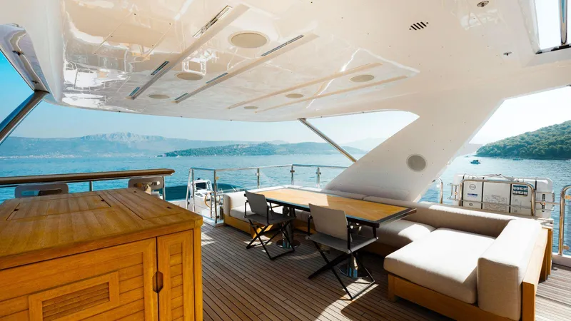 Afina Yacht Photos Pics Luxurious 2017 Benetti 108 yacht deck with seating, table, and ocean view.