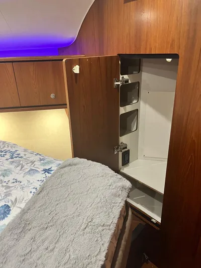 Nola Yacht Photos Pics Interior of 2007 Tiara Yachts 3900 Sovran with open wooden cabinet and cozy bedding.