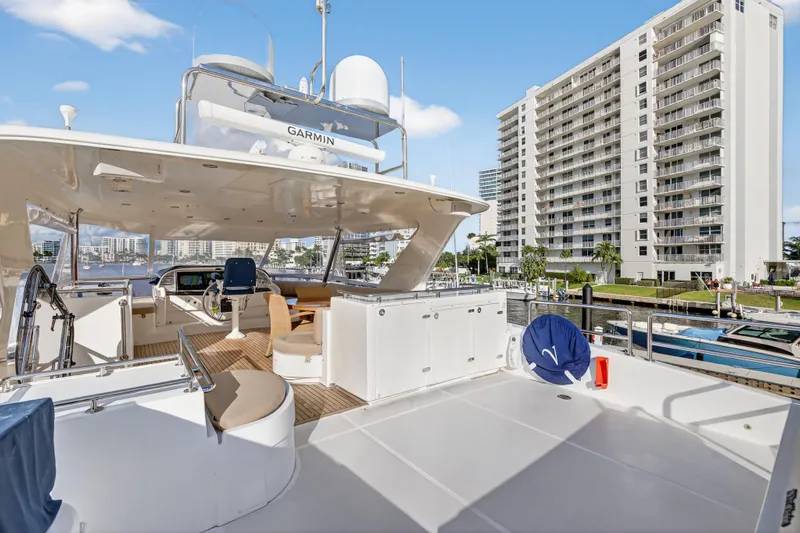 Arlene Yacht Photos Pics Luxurious 2009 Horizon Flybridge yacht docked near modern high-rise buildings.