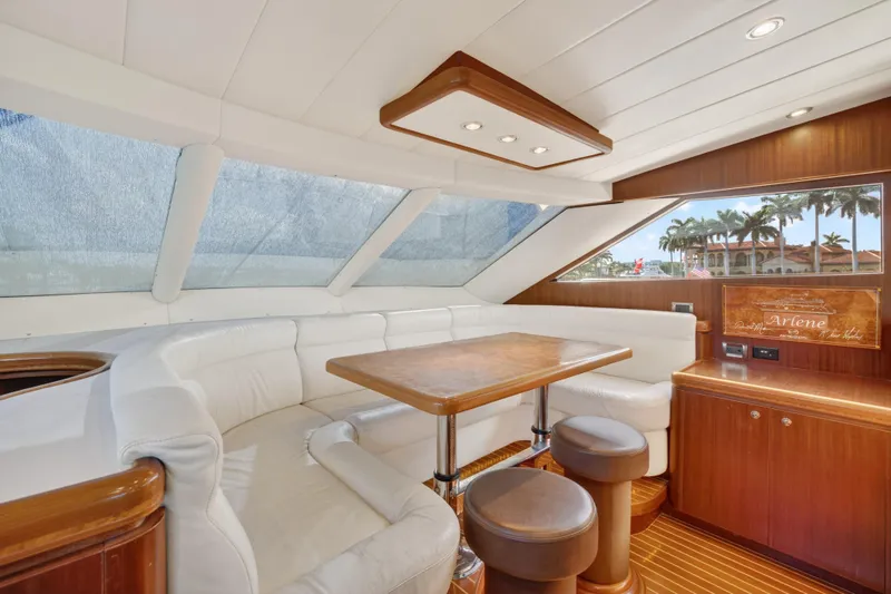 Arlene Yacht Photos Pics Luxurious 2009 Horizon Flybridge yacht interior with white seating, wooden table, and panoramic windows.