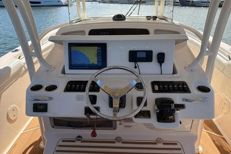  Yacht Photos Pics 2018 Grady-White Canyon 336 helm with navigation display and controls, docked by the water.